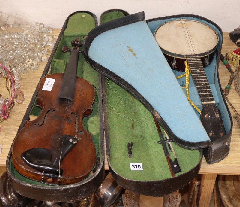 An early 20th century Saxon violin cased with bow and a cased banjo